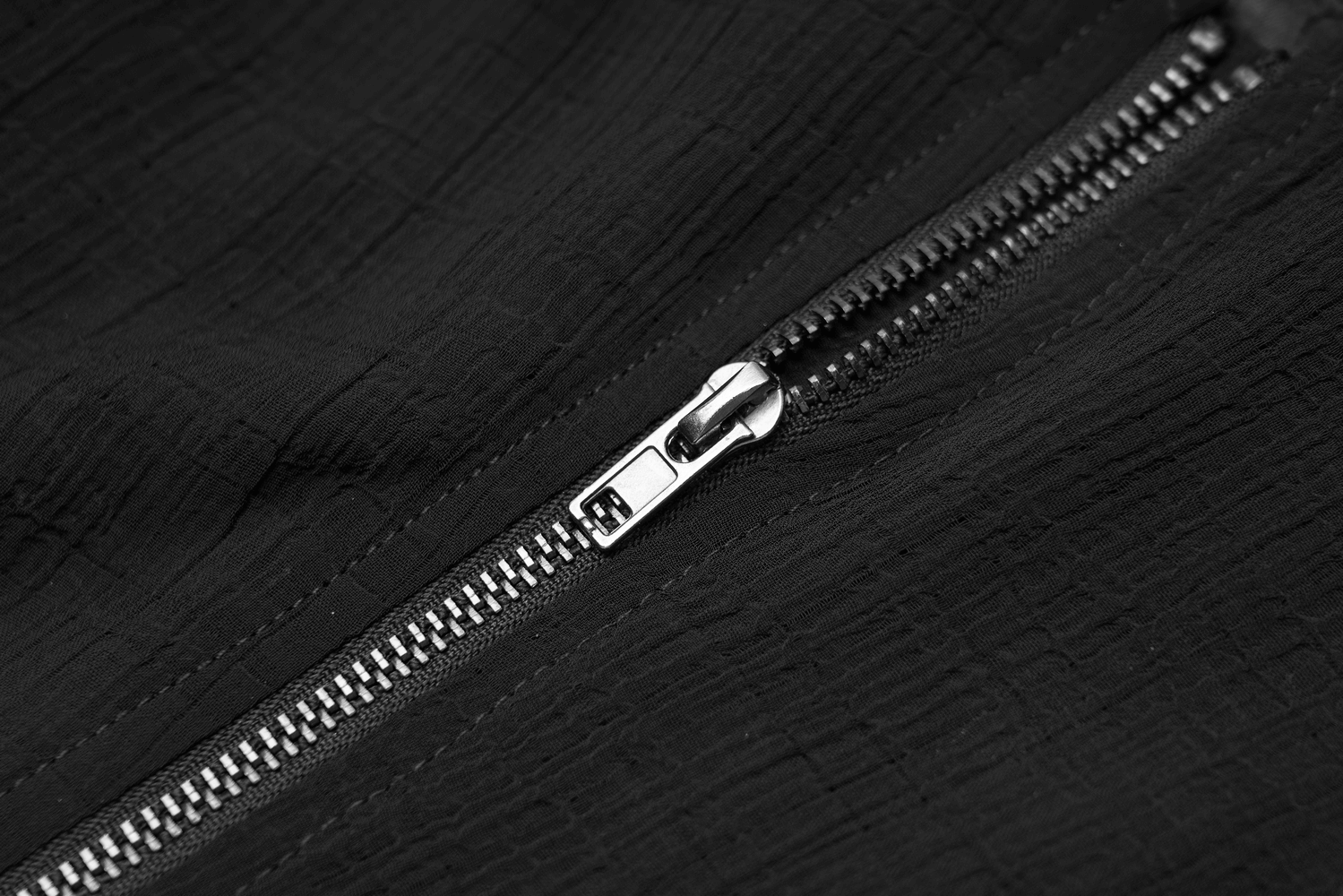 Close-up of a sleek black zipper highlighting elegant texture and modern design.