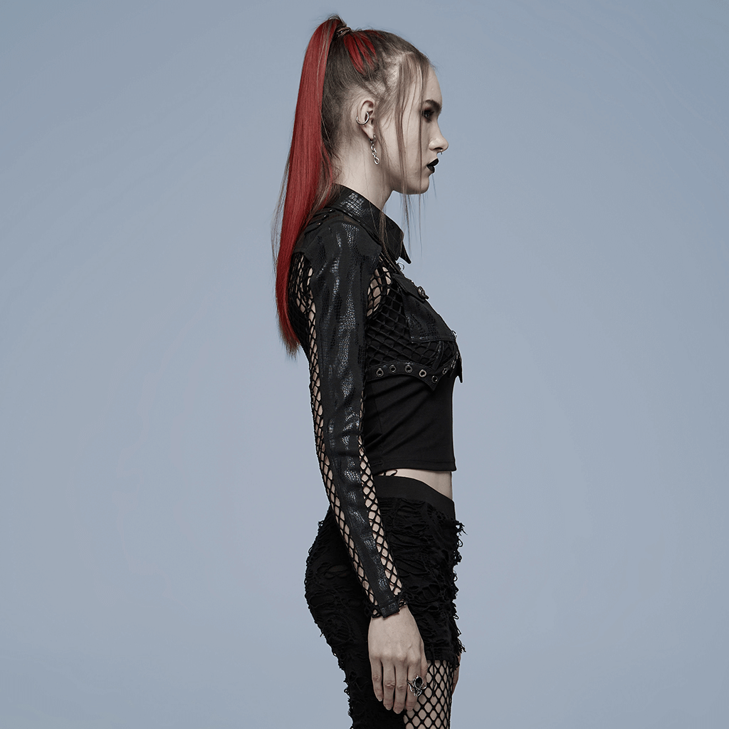 Gothic punk model in fishnet-sleeve crop top with leather accents, showcasing edgy fashion in a minimalist setting.