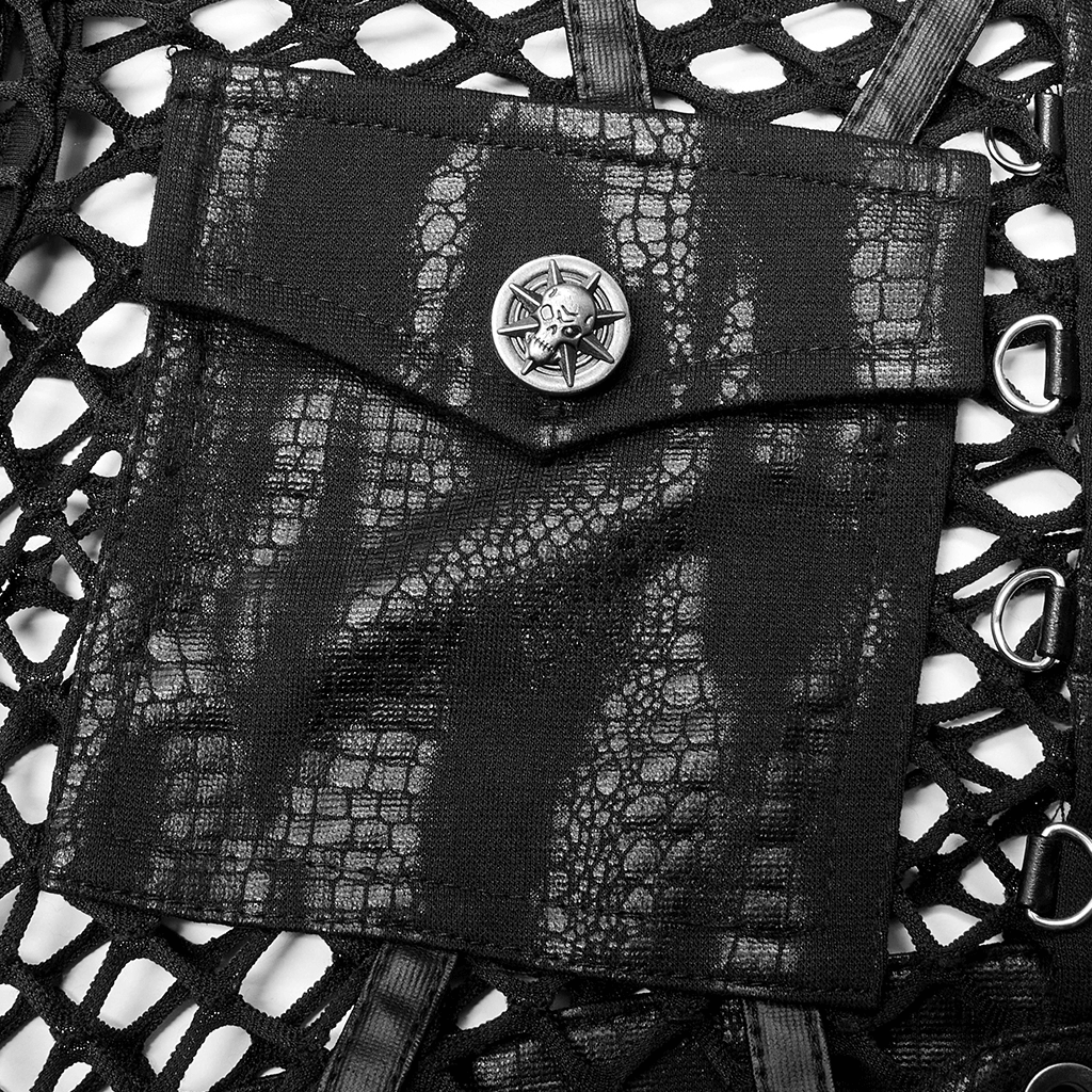 Close-up of gothic crop top featuring a textured black pocket with skull button and intricate fishnet detailing.