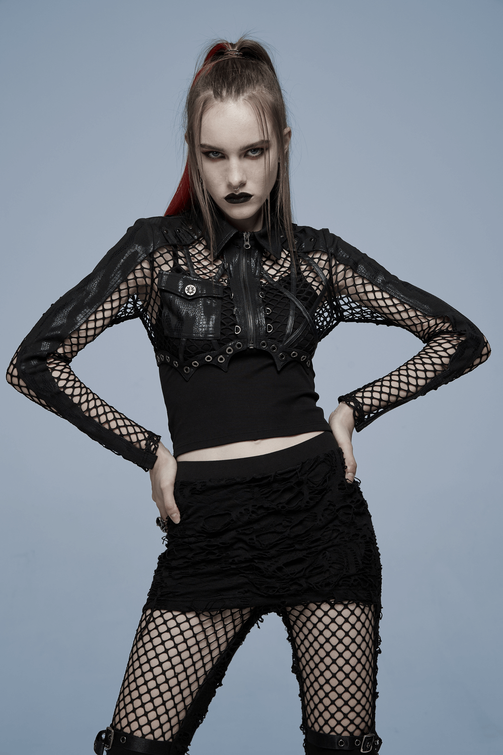 Chic gothic punk crop top with fishnet sleeves and leather accents, styled for an edgy, avant-garde look.