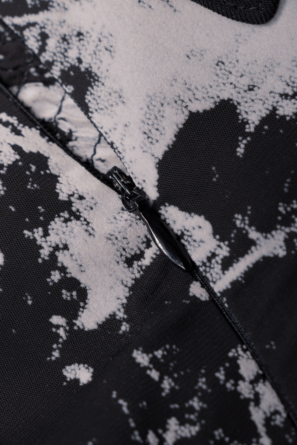 Close-up of a zipper on a stylish black and white abstract A-line mini dress, showcasing unique flock design.