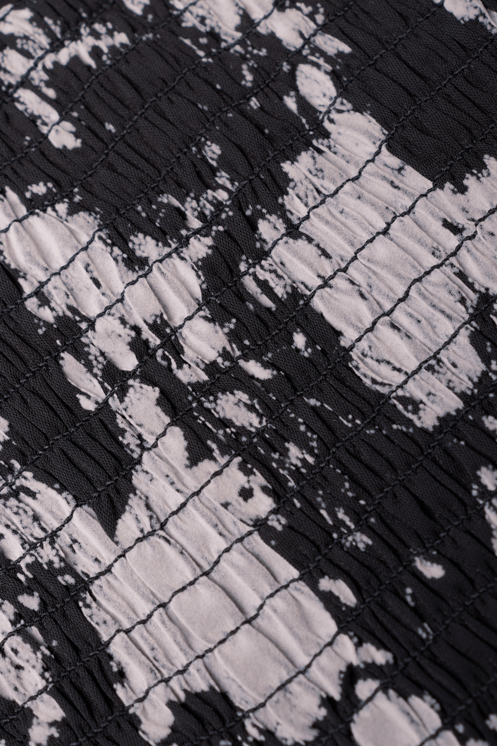 Close-up of black and white abstract flock pattern on soft, woven fabric for a chic mini dress.