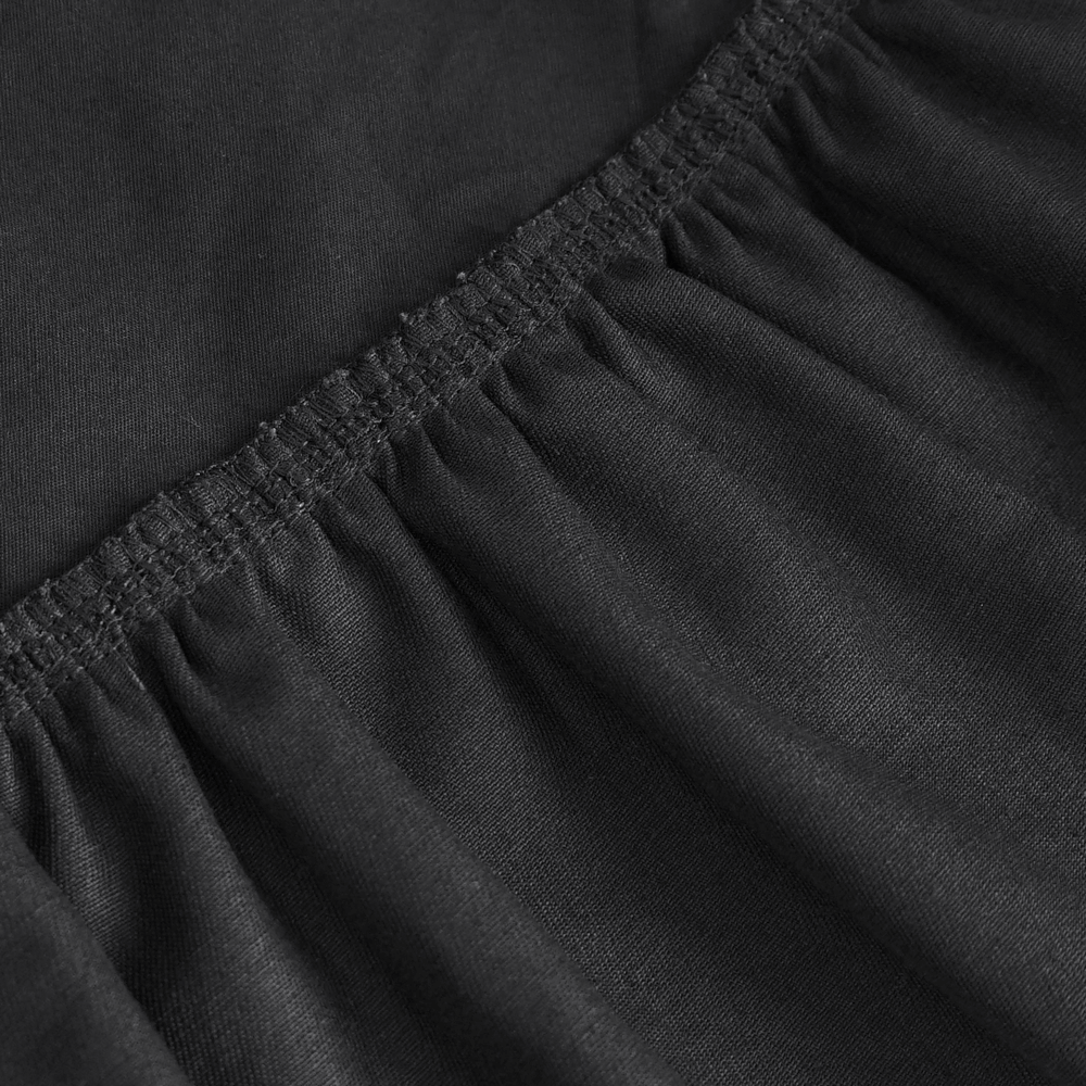 Close-up of the ruffle hem and elastic waistband of a chic black gothic punk skirt.