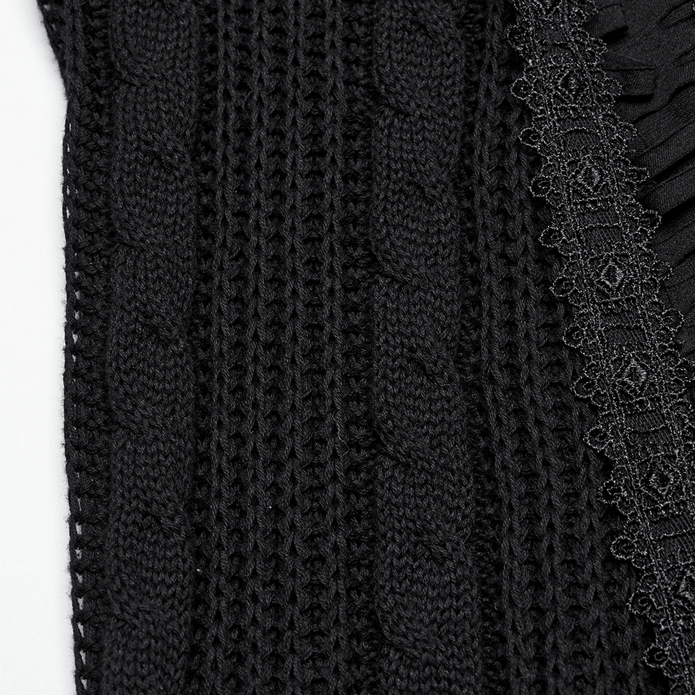 Close-up of a chic gothic tattered black knit fabric with lace detailing and distressed textures.