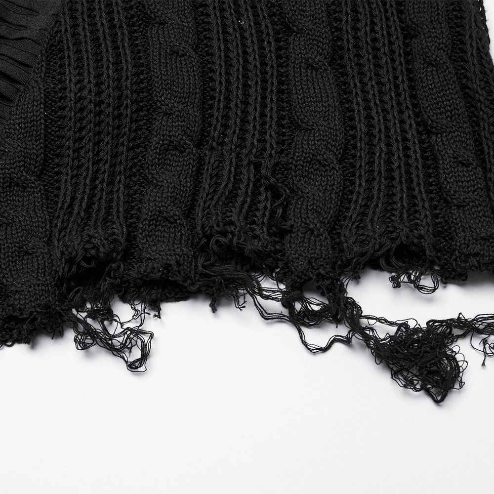 Close-up of a chic gothic tattered black knit skirt with distressed edges and textured patterns.