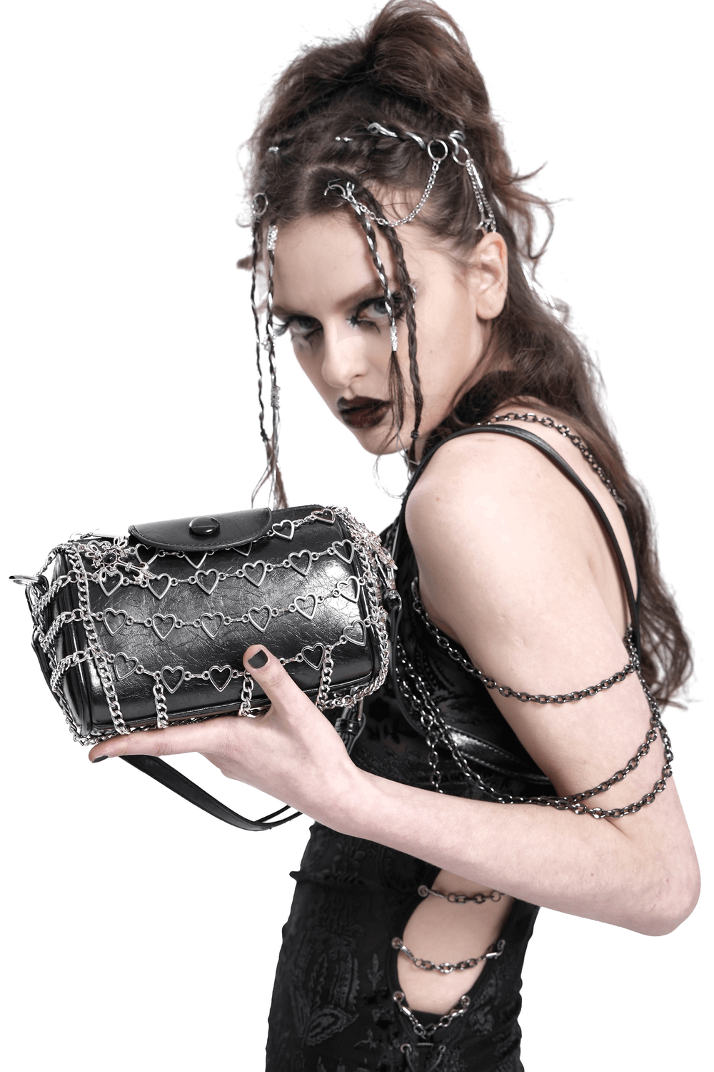 Trendy black heart-pattern chain crossbody bag for women, styled with edgy accessories and a chic appearance.
