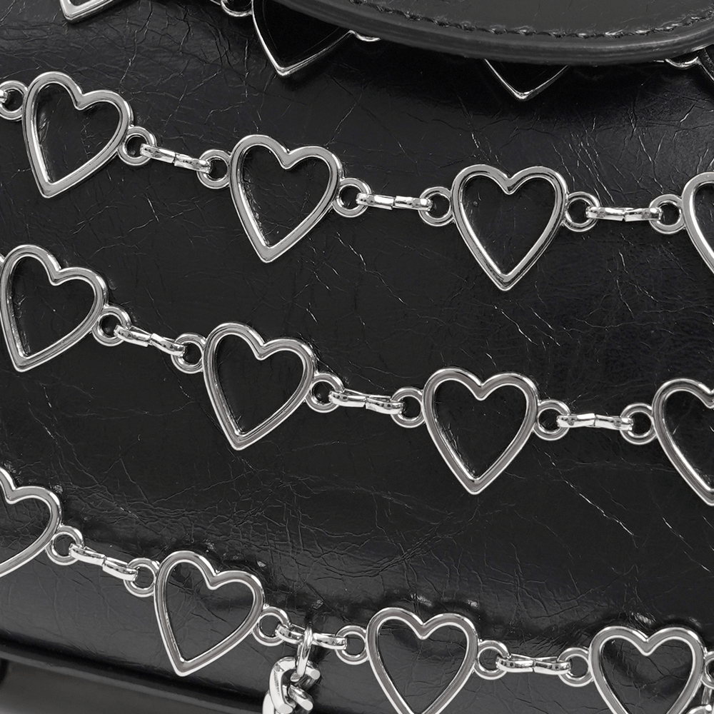 Close-up of chic black crossbody bag featuring stylish heart-patterned chain detailing for women.