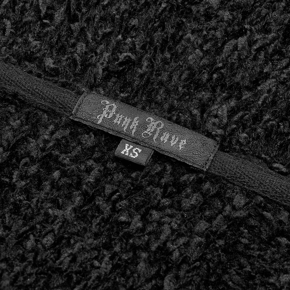 Close-up view of the 'Pink Love' label on a luxurious black woolen cloak.