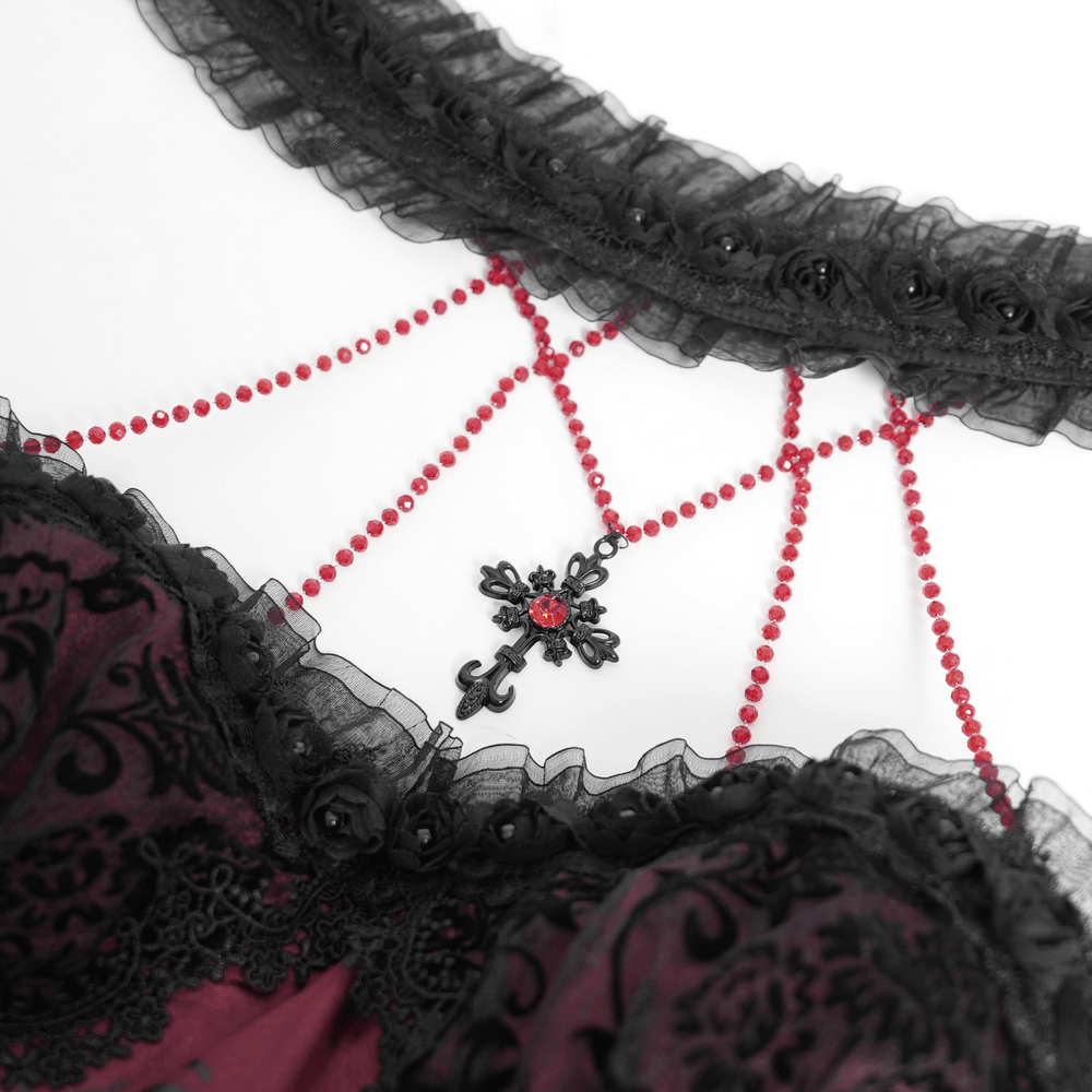 Close-up of red beaded detailing on a gothic dress, featuring lace and floral accents for a dramatic look.