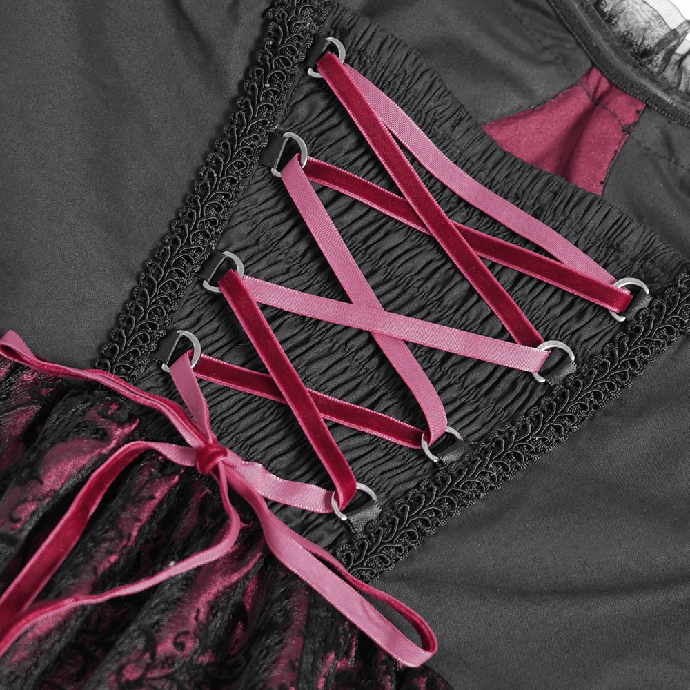 Close-up of black and burgundy corset dress lacing with pink ribbons and intricate lace details.