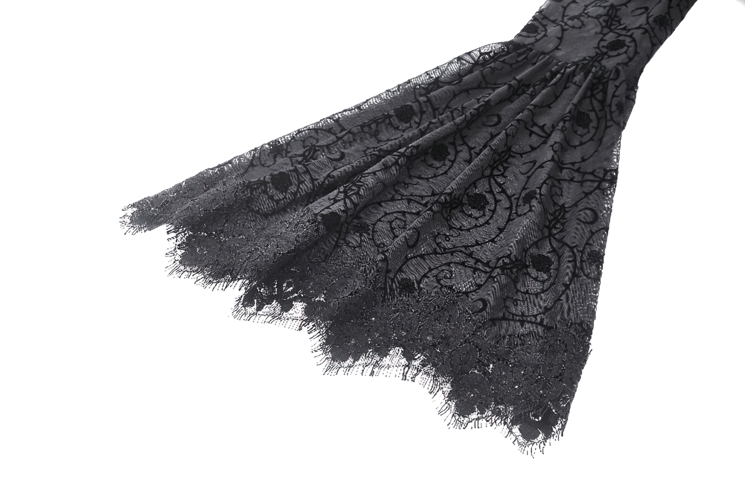 Intricate lace detailing of a chic black gothic dress, featuring delicate floral patterns and flared sleeve ends.