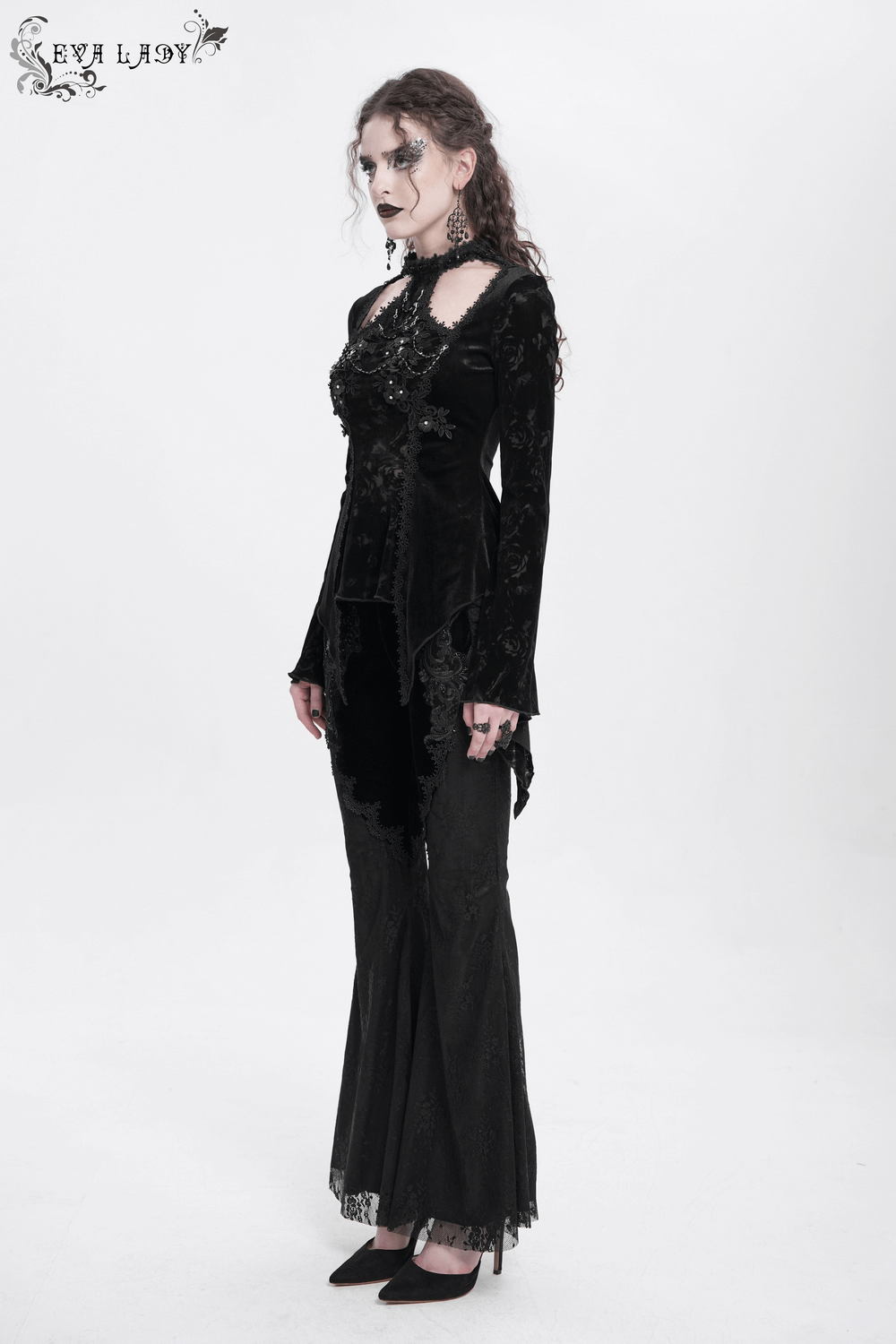 Elegant gothic model in black lace long-sleeved top with pearls, showcasing dark elegance and sophistication.