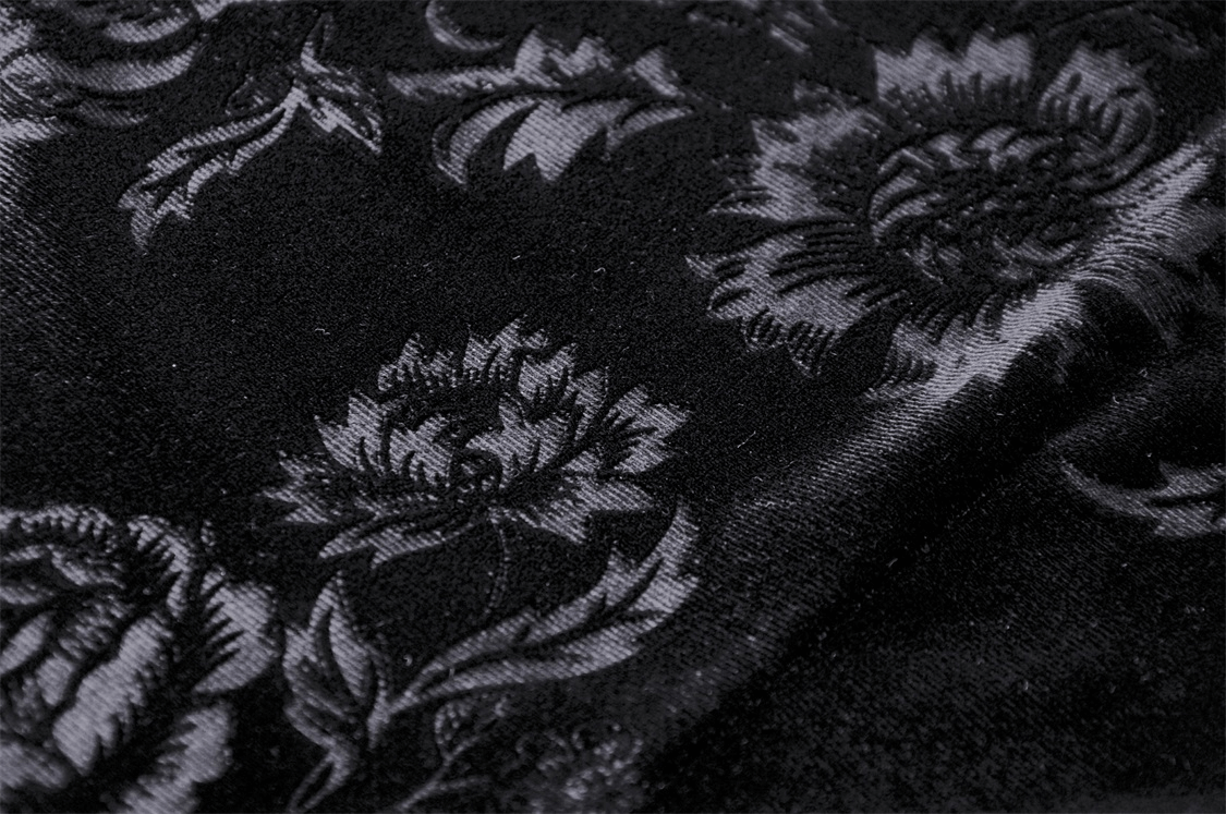 Close-up of black lace fabric featuring intricate floral patterns, perfect for a chic off-the-shoulder top.