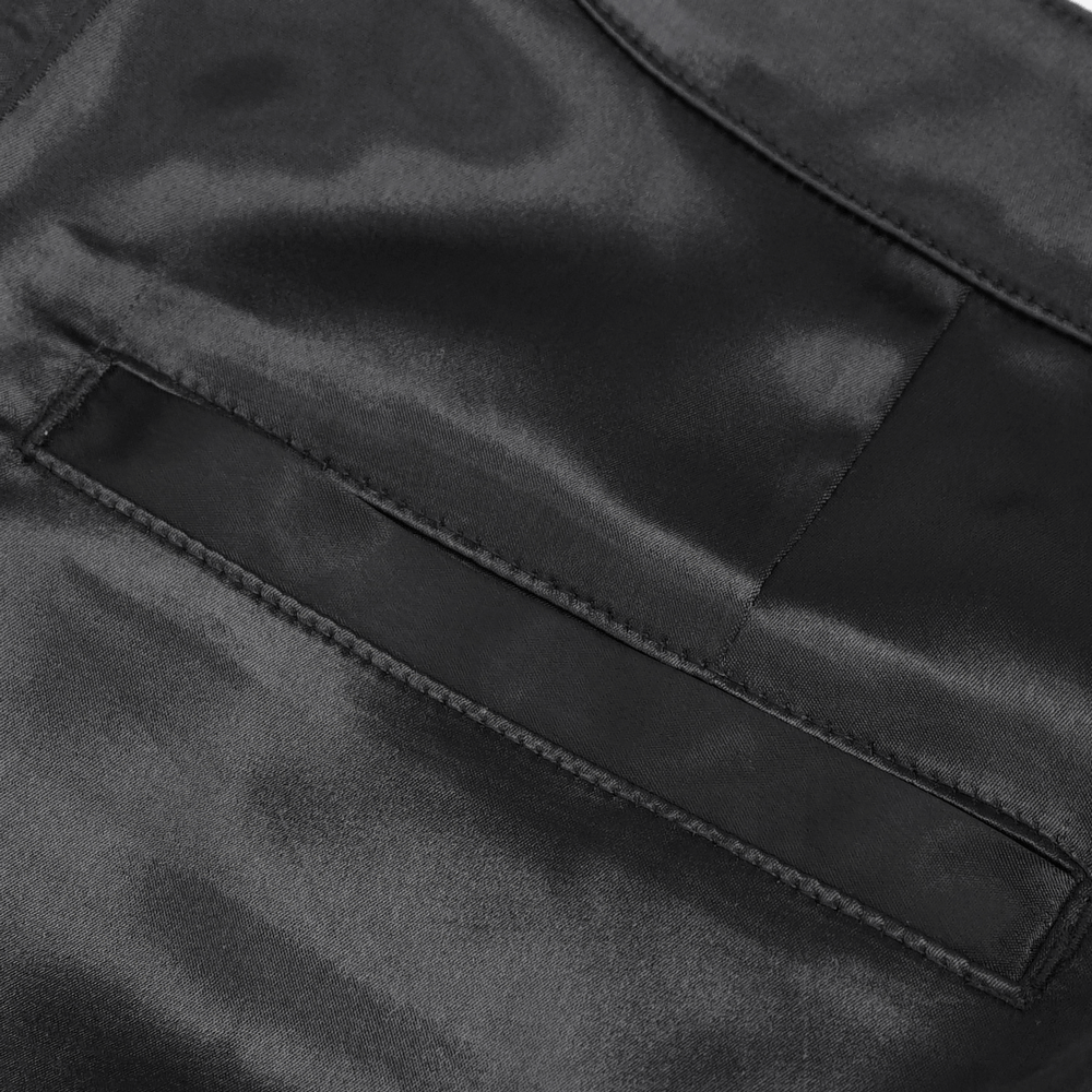 Close-up of sleek black satin fabric showcasing fine stitching and pocket detail for gothic flared pants.