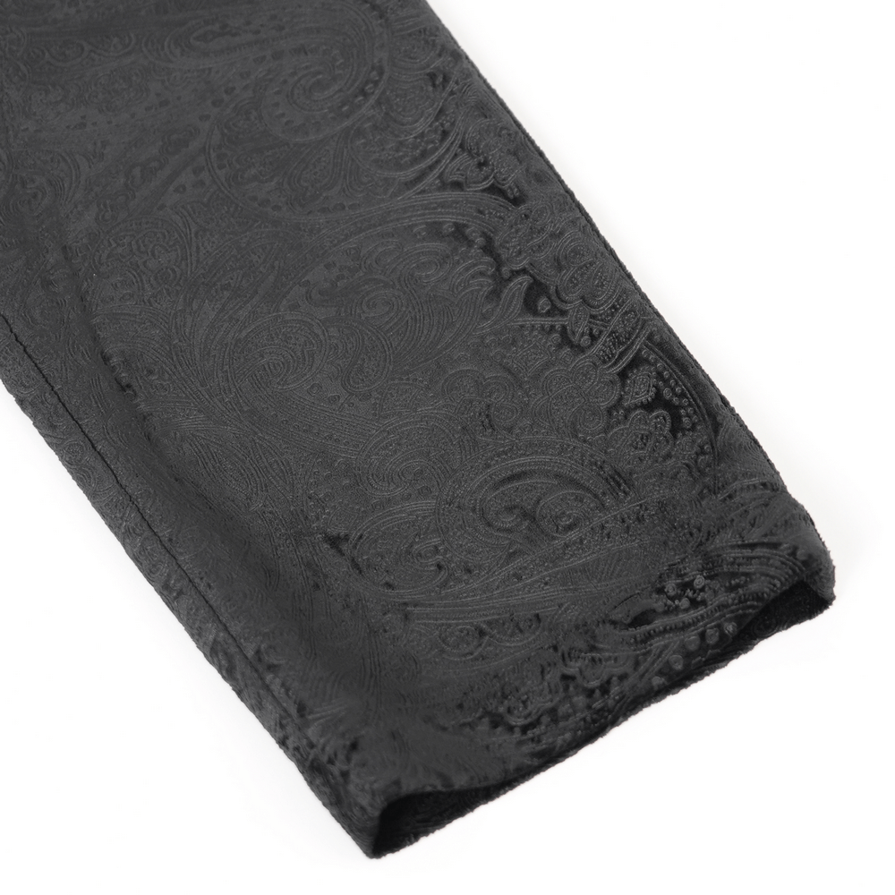 Chic black jacquard fabric close-up showing intricate lace details on stylish men's trousers.