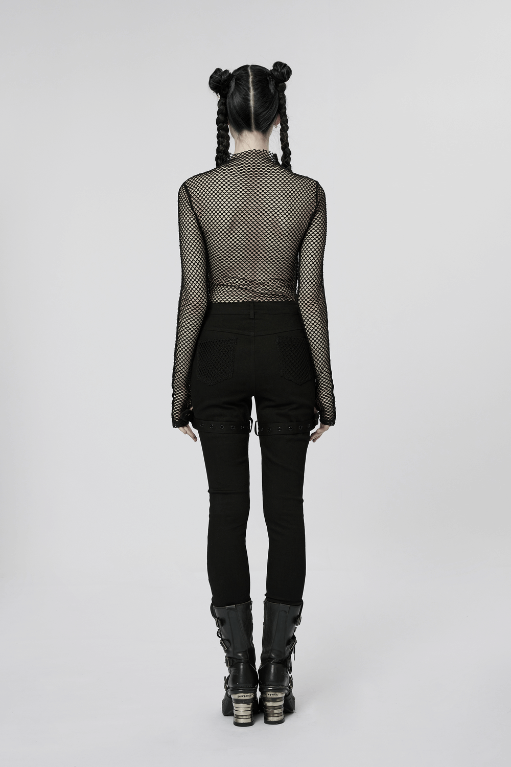 Back view of a model in mesh top and black gothic trousers with eyelets, showcasing punk style fashion.