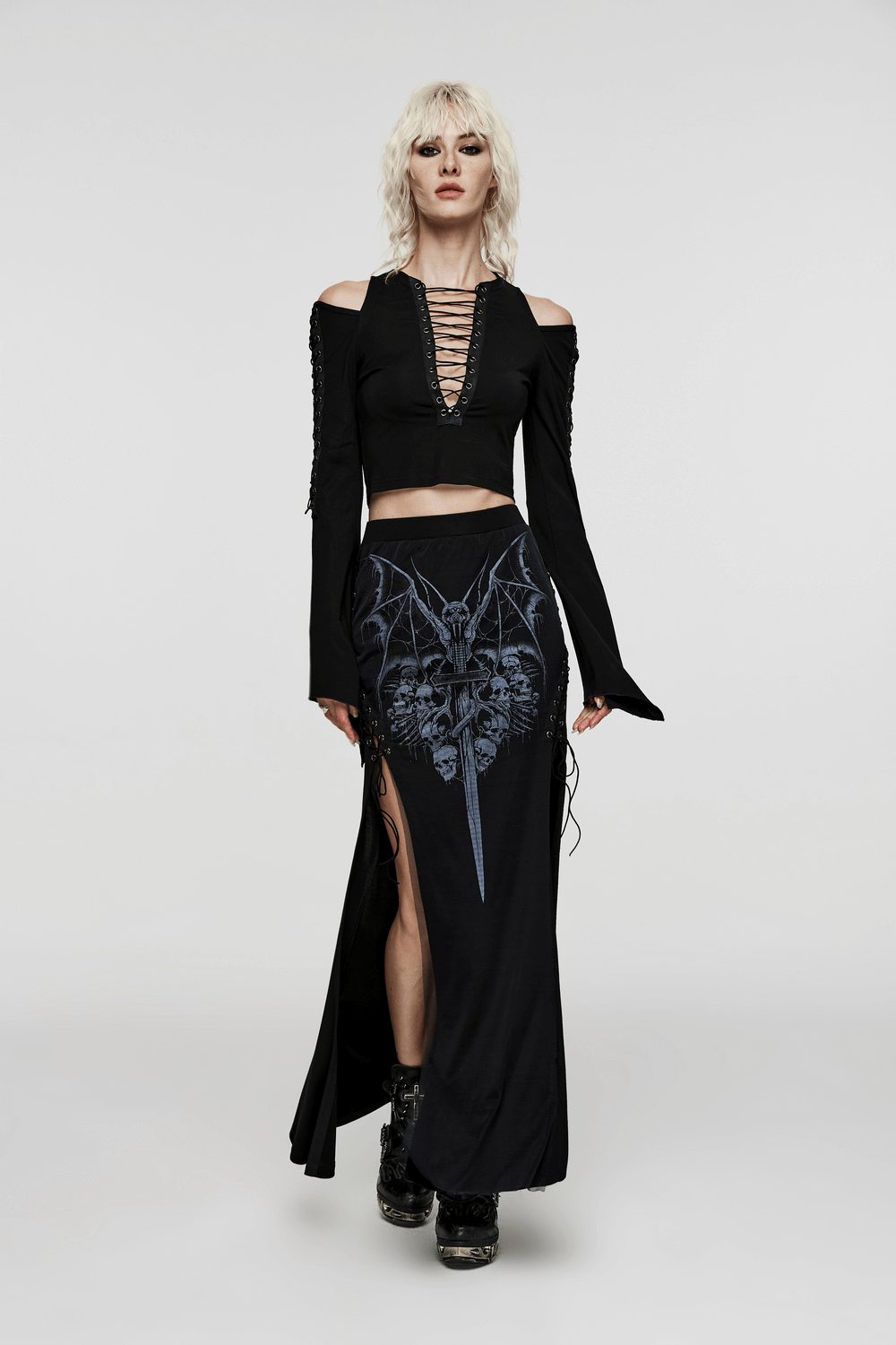 Chic off-shoulder goth top with lace-up detailing and flowing skirt, embodying bold gothic fashion.