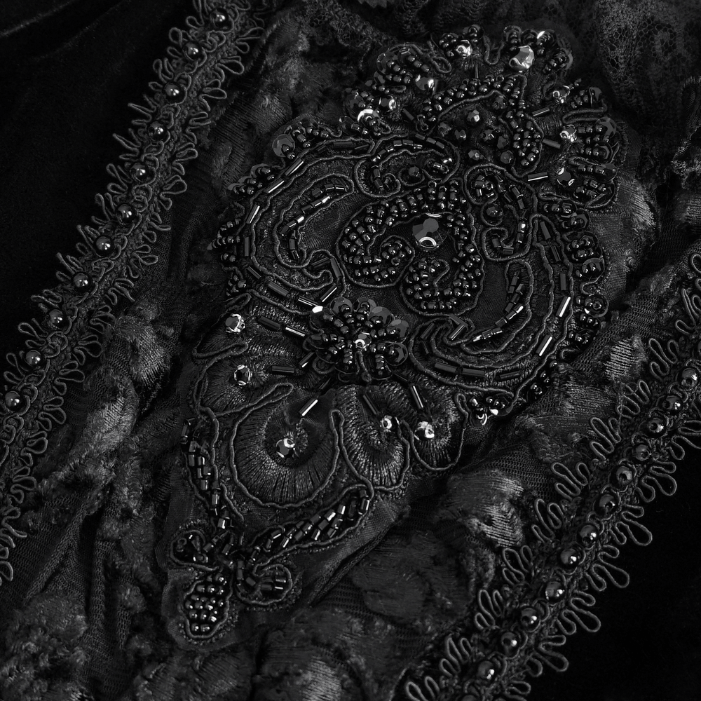 Intricate black lace and beaded embroidery detail on a chic off-the-shoulder top, highlighting gothic elegance.