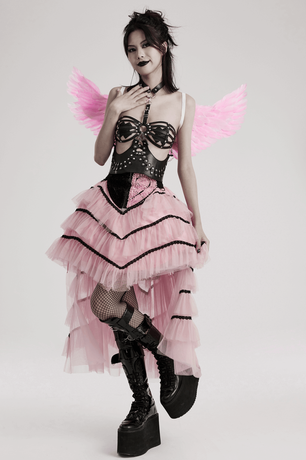 Model showcasing chic pink feathered angel wings harness with silver chains, perfect for festivals and events.