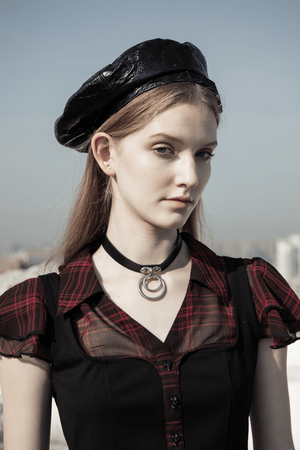 Model showcasing chic plaid A-Line dress with falbala sleeves and leather beret against a city backdrop.