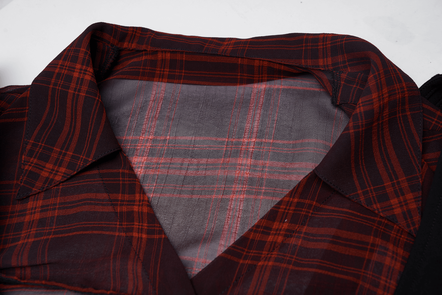 Close-up of the V-neck detail and plaid pattern of the chic A-Line dress in red and black.