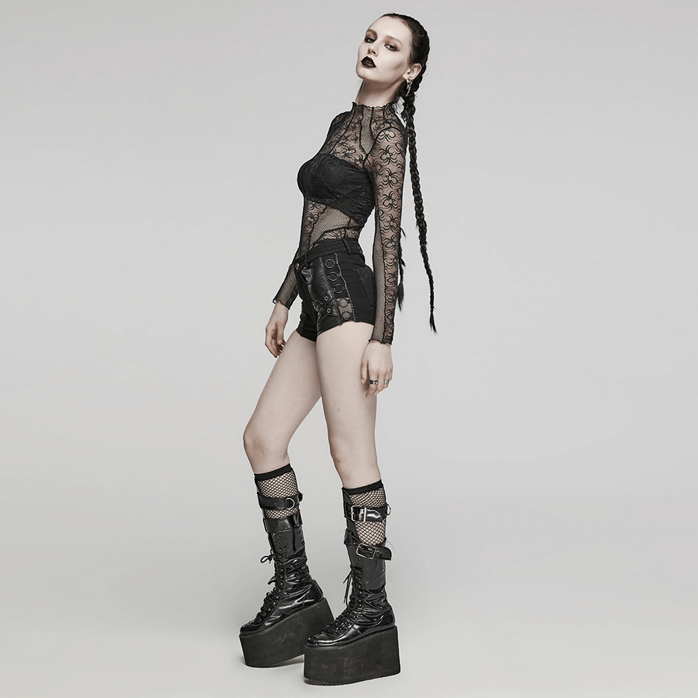 Edgy model in black lace top and punk rivet-embellished shorts, showcasing daring streetwear style and bold footwear.