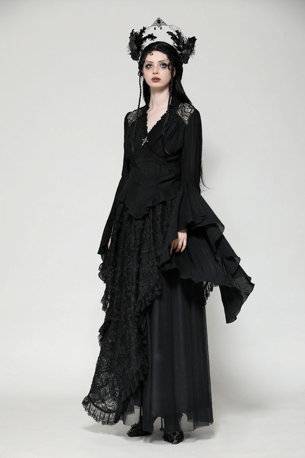 Gothic elegance in black ruffled top with lace and brooch, featuring dramatic bell sleeves and vintage charm. Perfect for alternative fashion.