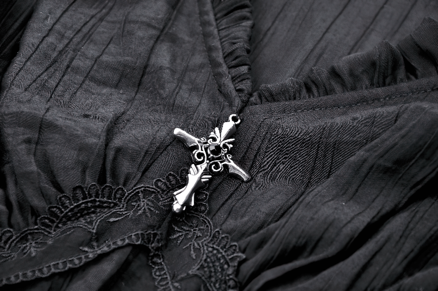 Black gothic top with ruffled lace and antique-style brooch detailing.