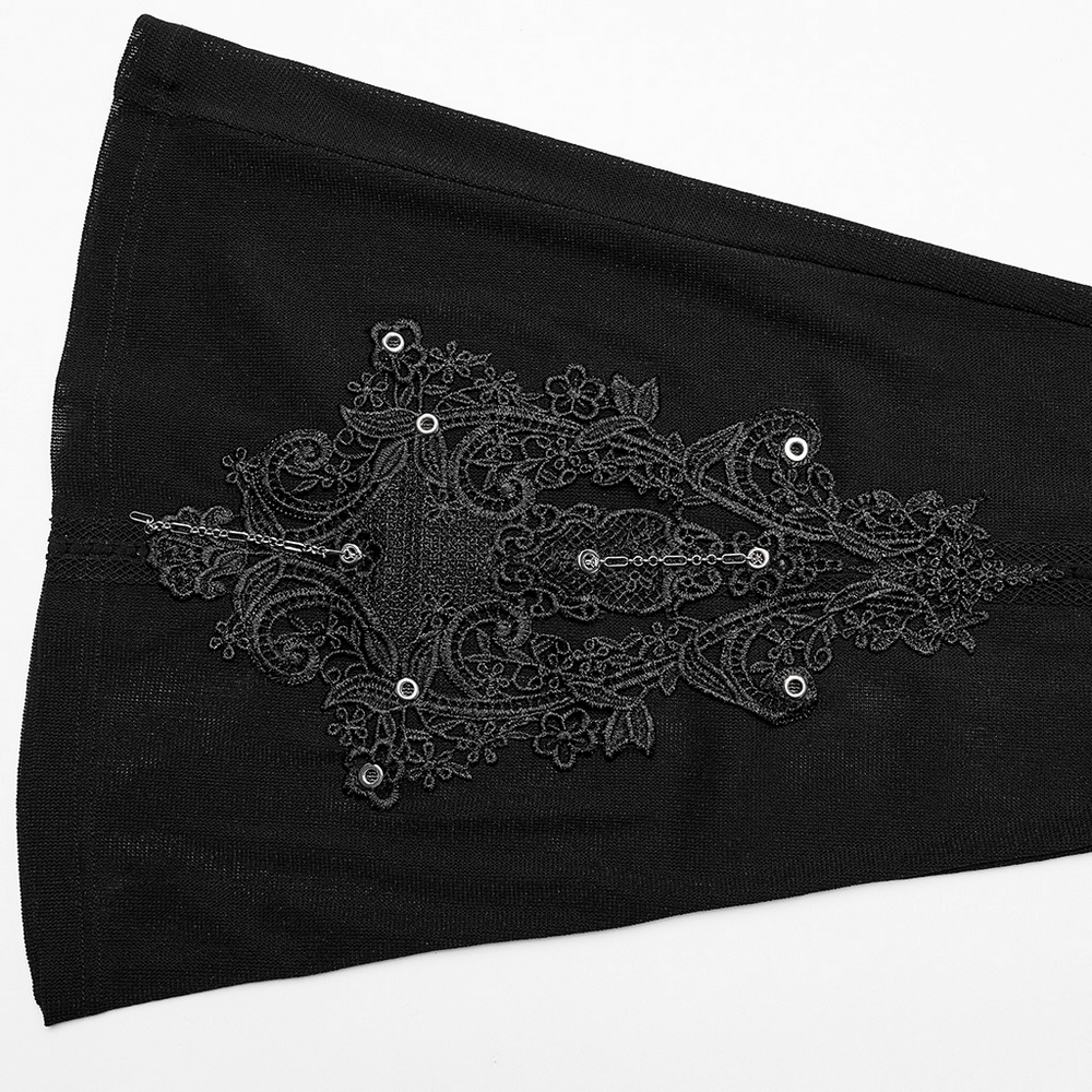 Close-up of intricate gothic lace detailing on sheer flare pants, featuring eyelets and floral patterns.