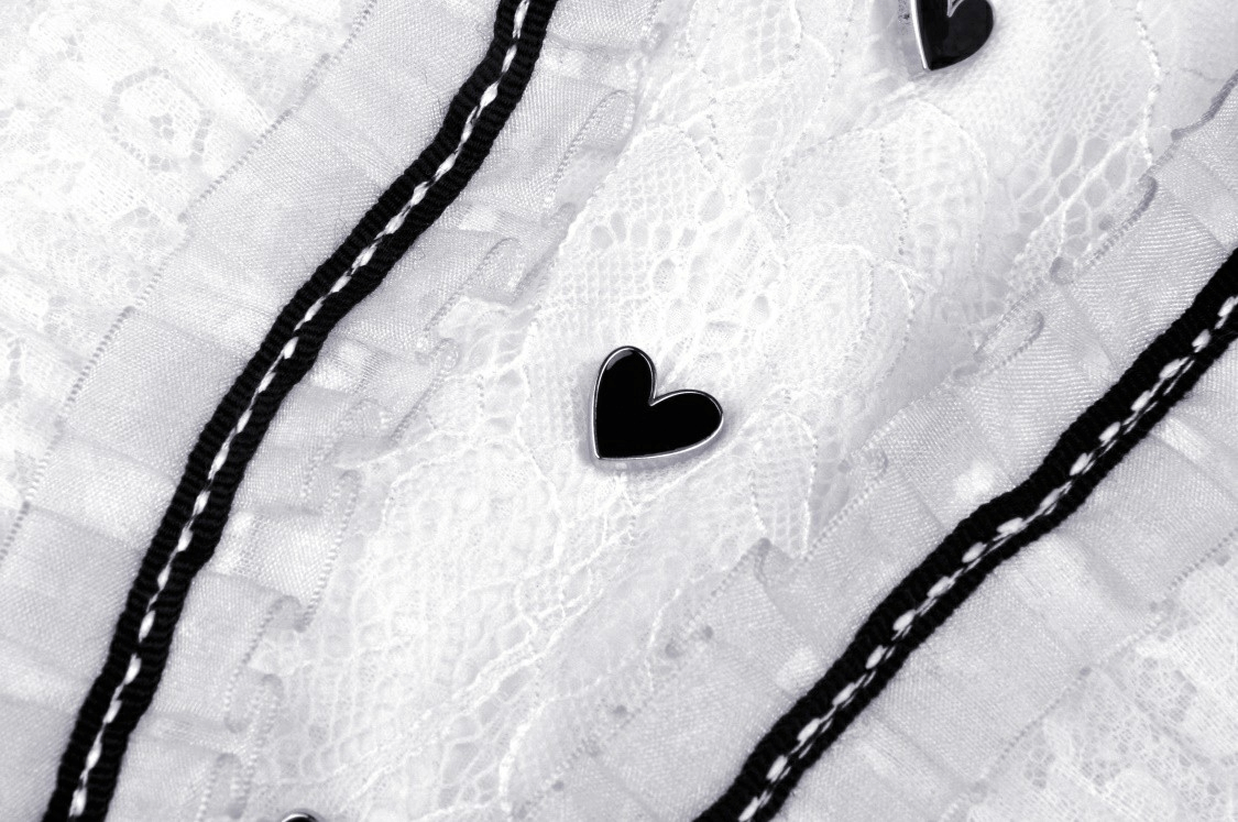 Close-up of delicate lace and black ribbon accents on a chic white dress, showcasing stylish heart-shaped embellishments.
