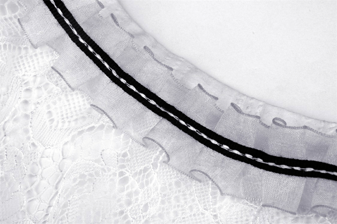 Close-up of the chic lace-trimmed collar with black ribbon accents on a white dress, highlighting elegant details.