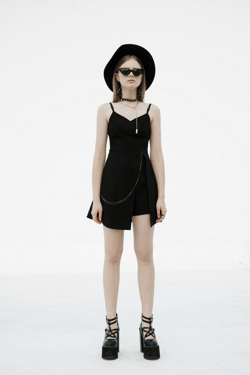 Chic V-neck dress with chain accent, showcasing a stylish silhouette and daring high slit on a model.