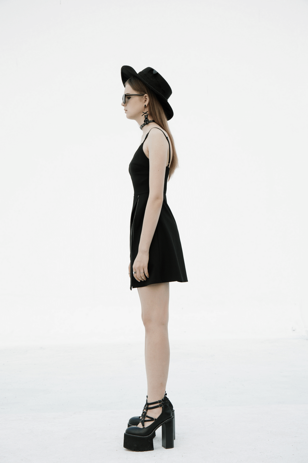 Chic V-neck dress with detachable chain accent, shown on a model with platform shoes and a stylish hat.