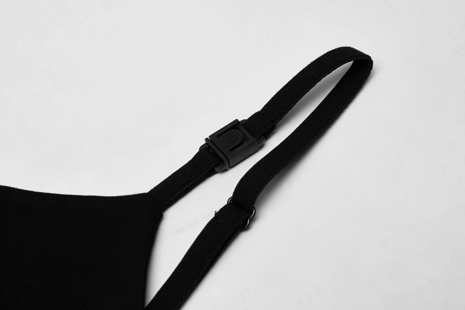 Close-up of adjustable shoulder strap detailing from a chic v-neck dress.