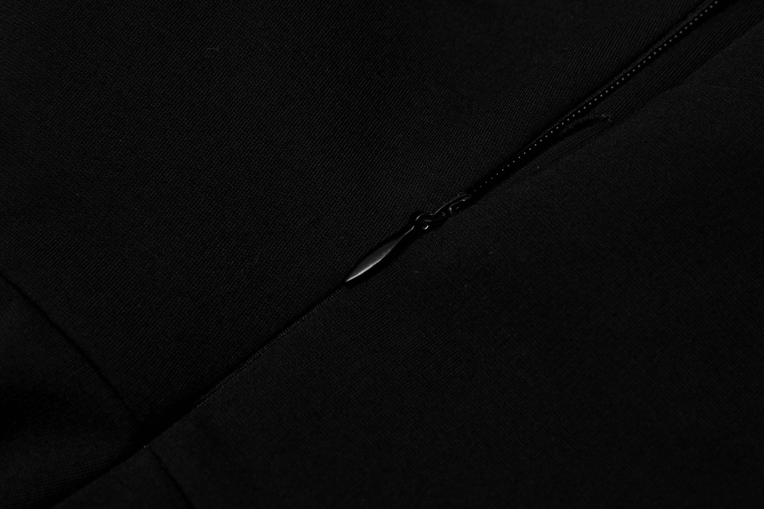 Close-up of chic black fabric detail featuring a stylish zipper accent.
