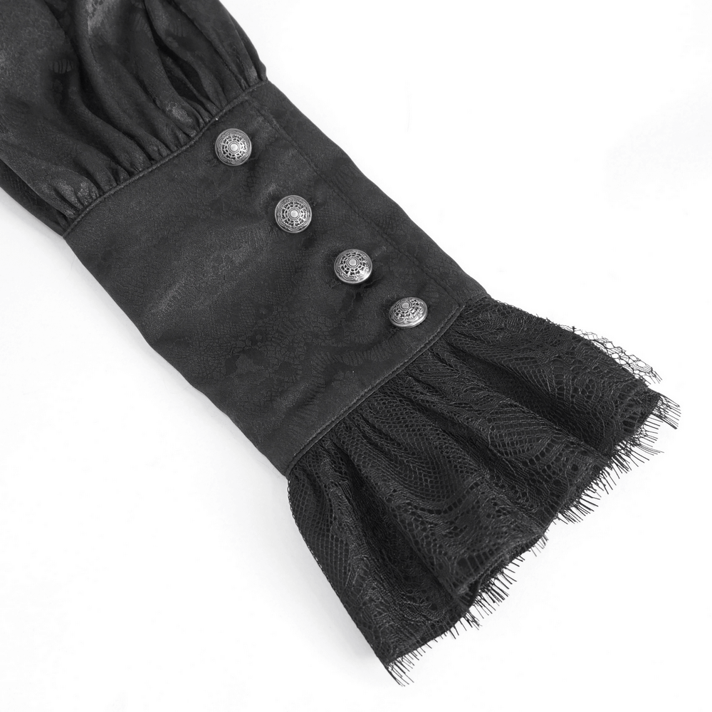 Close-up of tassel sleeve and decorative buttons on a chic black lace shirt, showcasing timeless elegance.