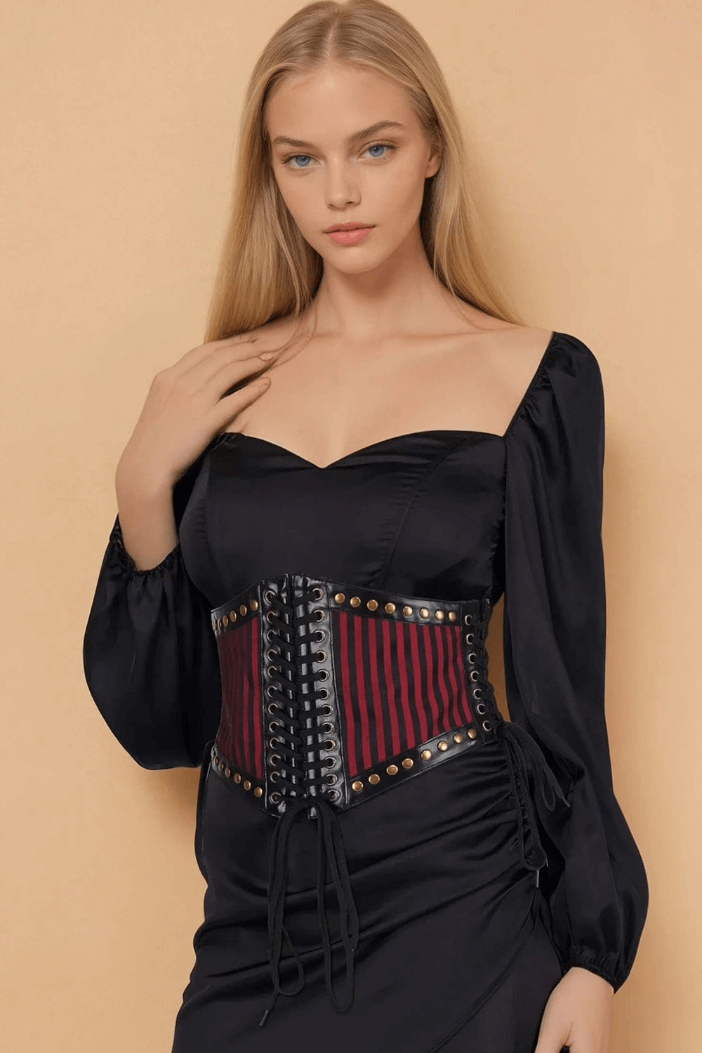 Chic woman wearing a wine red corset-inspired belt with rivet details and dual lacing, styled elegantly.