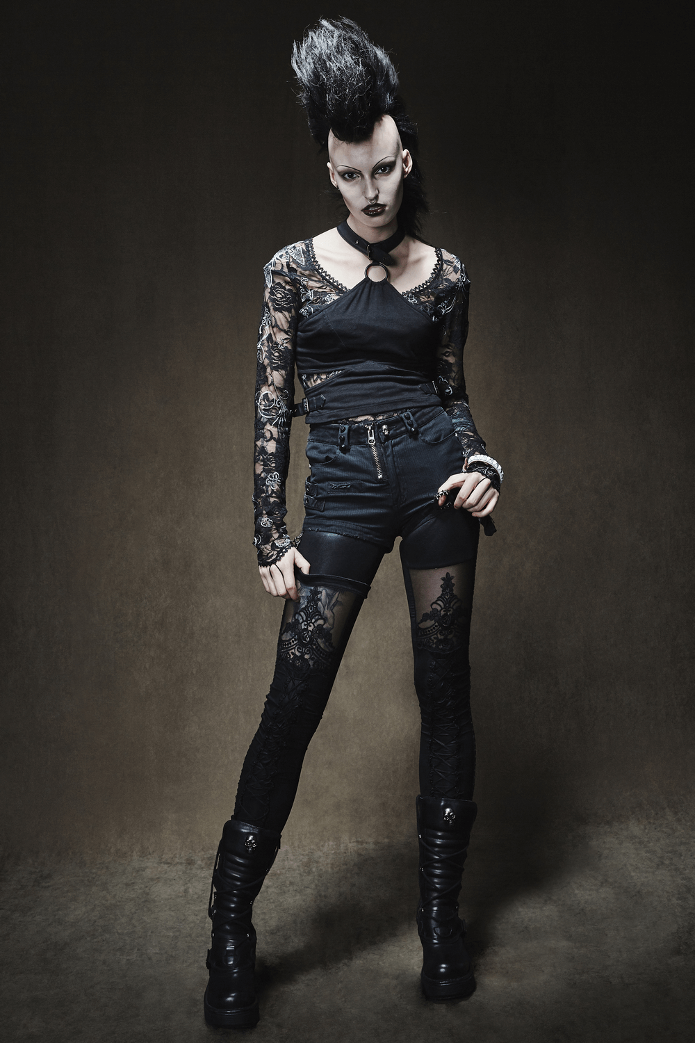 Fashionable model in black lace top and shorts, showcasing edgy style with high-waisted lace leggings and chunky boots.
