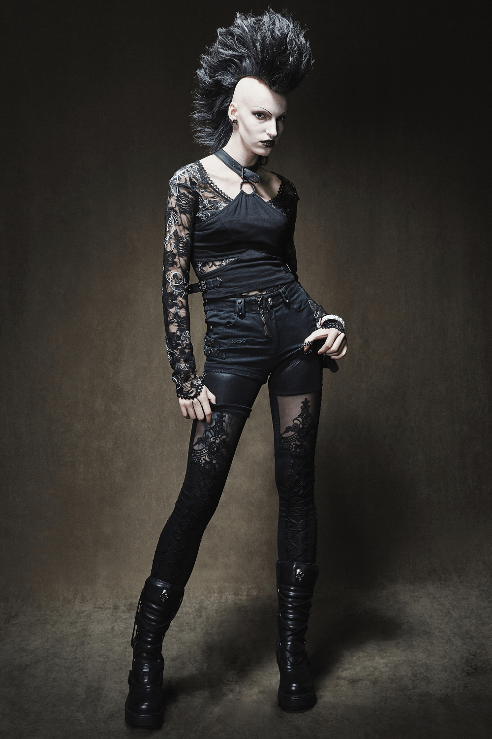 Edgy model in chic black lace leggings and short top, showcasing a punk-inspired fashion style.