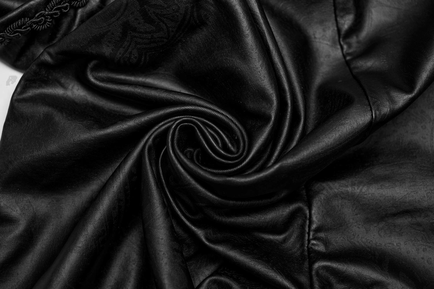 Close-up of sleek black fabric showcasing its glossy, luxurious texture, perfect for chic women's leggings.