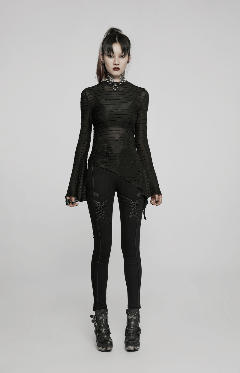 Chic woman in Gothic lace-up skinny jeans and stylish black top, showcasing punk fashion with edgy accessories.