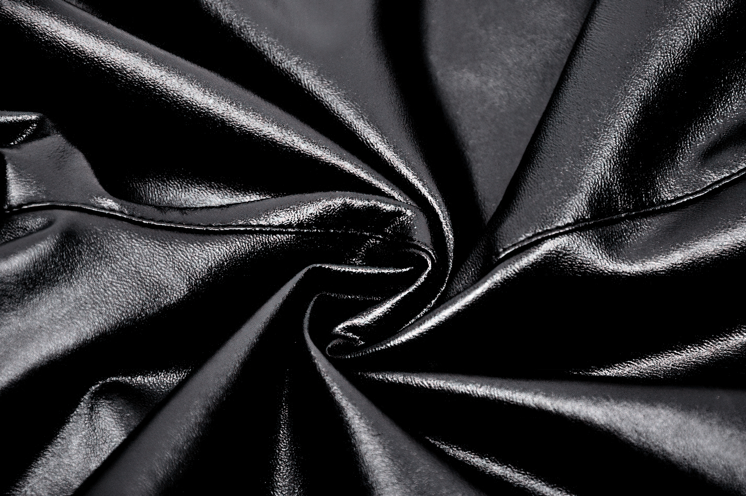 Close-up of glossy black PU leather fabric, perfect for chic women's leggings with an edgy gothic style.