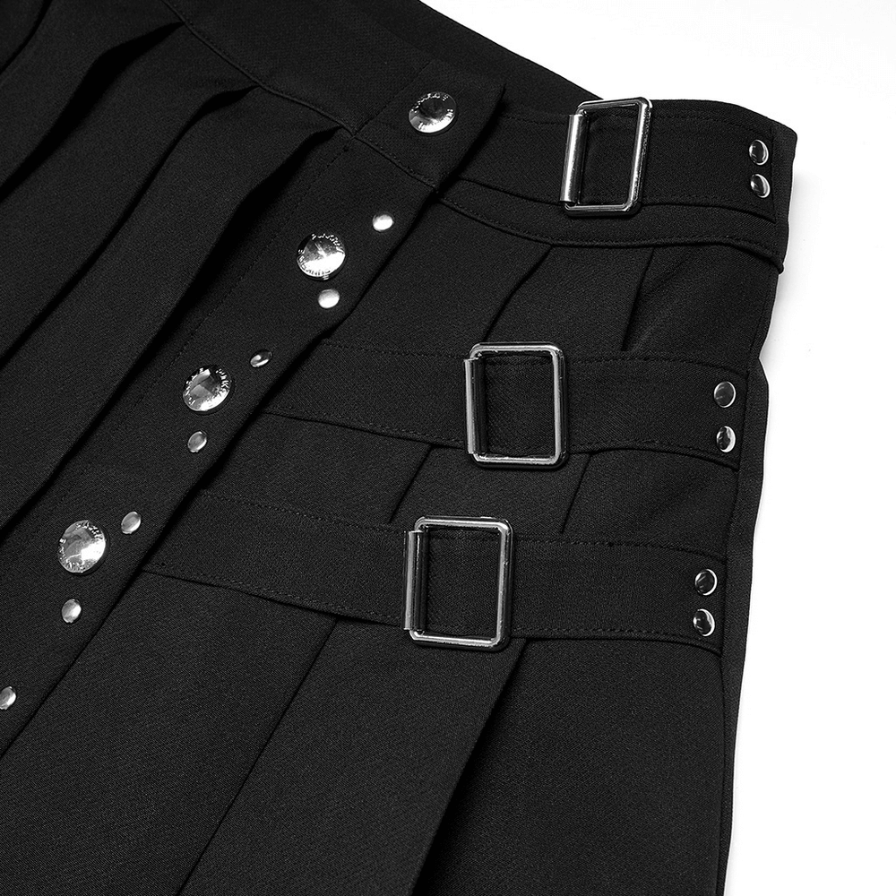Chic women's punk pleated mini skirt showing decorative rivets and buckle details in black fabric.