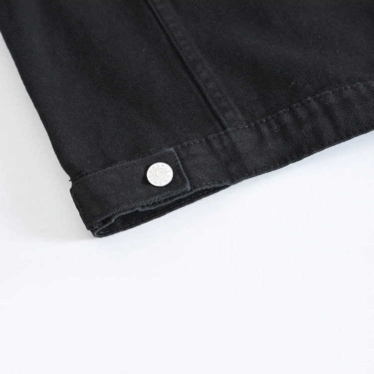 Close-up of the hem detail and button on a classic black men's vest, showcasing rock style and vintage denim design.
