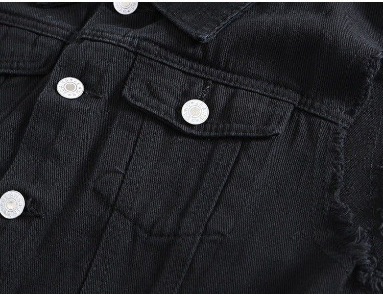 Close-up of classic black denim vest with white buttons and ripped sleeve details, perfect for rock style outfits.