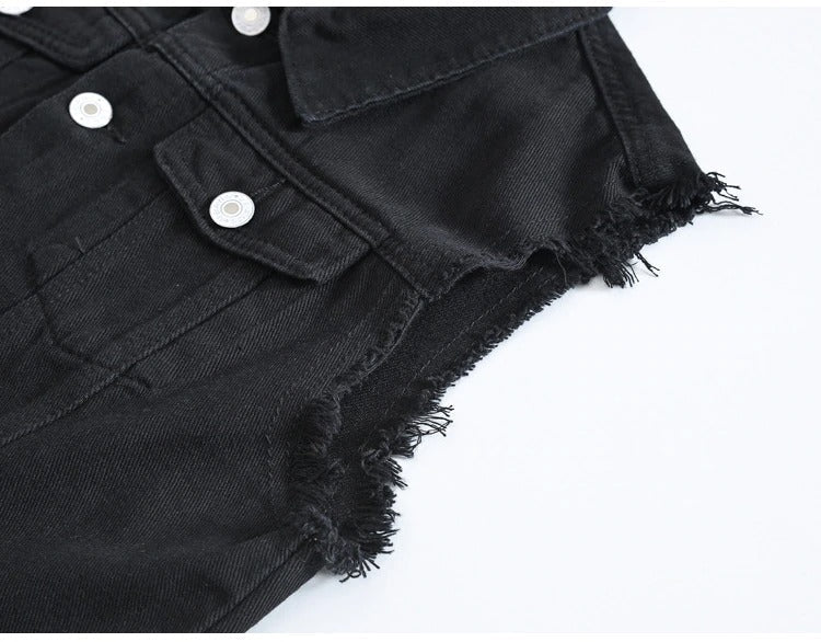 Close-up of the edgy black denim vest with ripped fringe edges and white buttons for a stylish rock look.