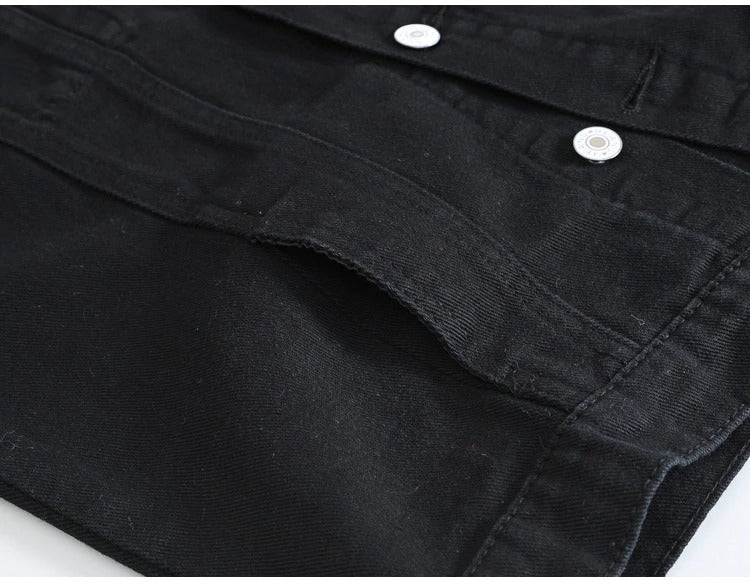Detail shot of classic black denim vest showing buttons and pocket for men in rock style.
