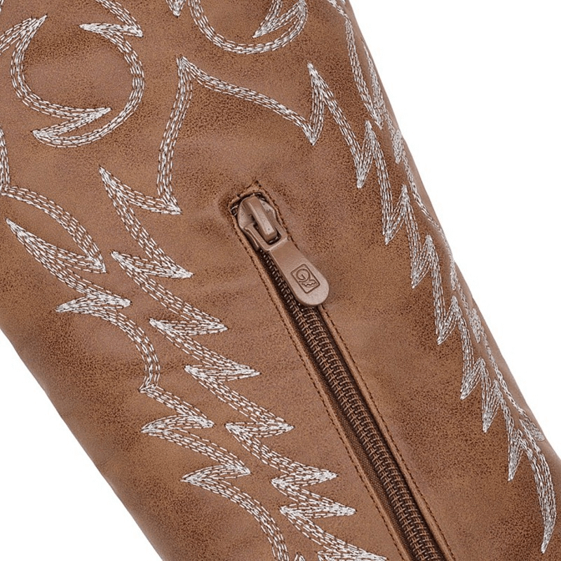 Close-up of brown knee-high boot with intricate embroidery and zipper detail, showcasing trendy cowboy style.