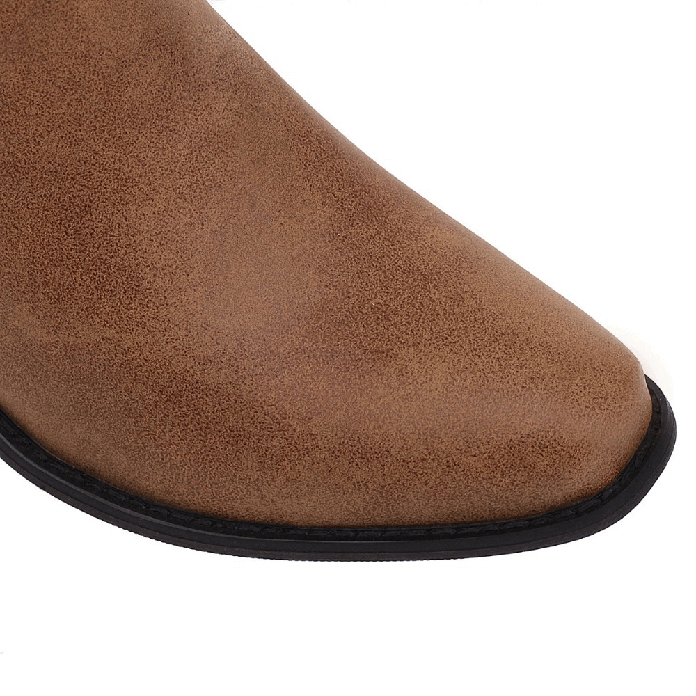 Close-up of the stylish brown toe of a classic knee-high boot with mid heels, perfect for trendy outfits.