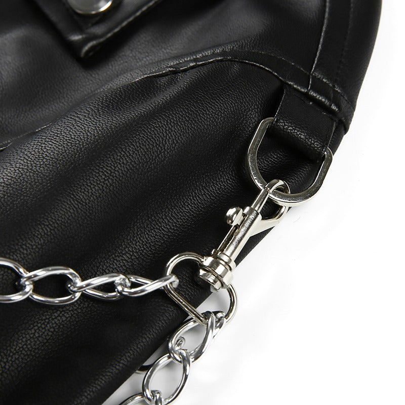 Close-up of black faux leather motorcycle jacket featuring chains and silver hardware for a stylish touch.